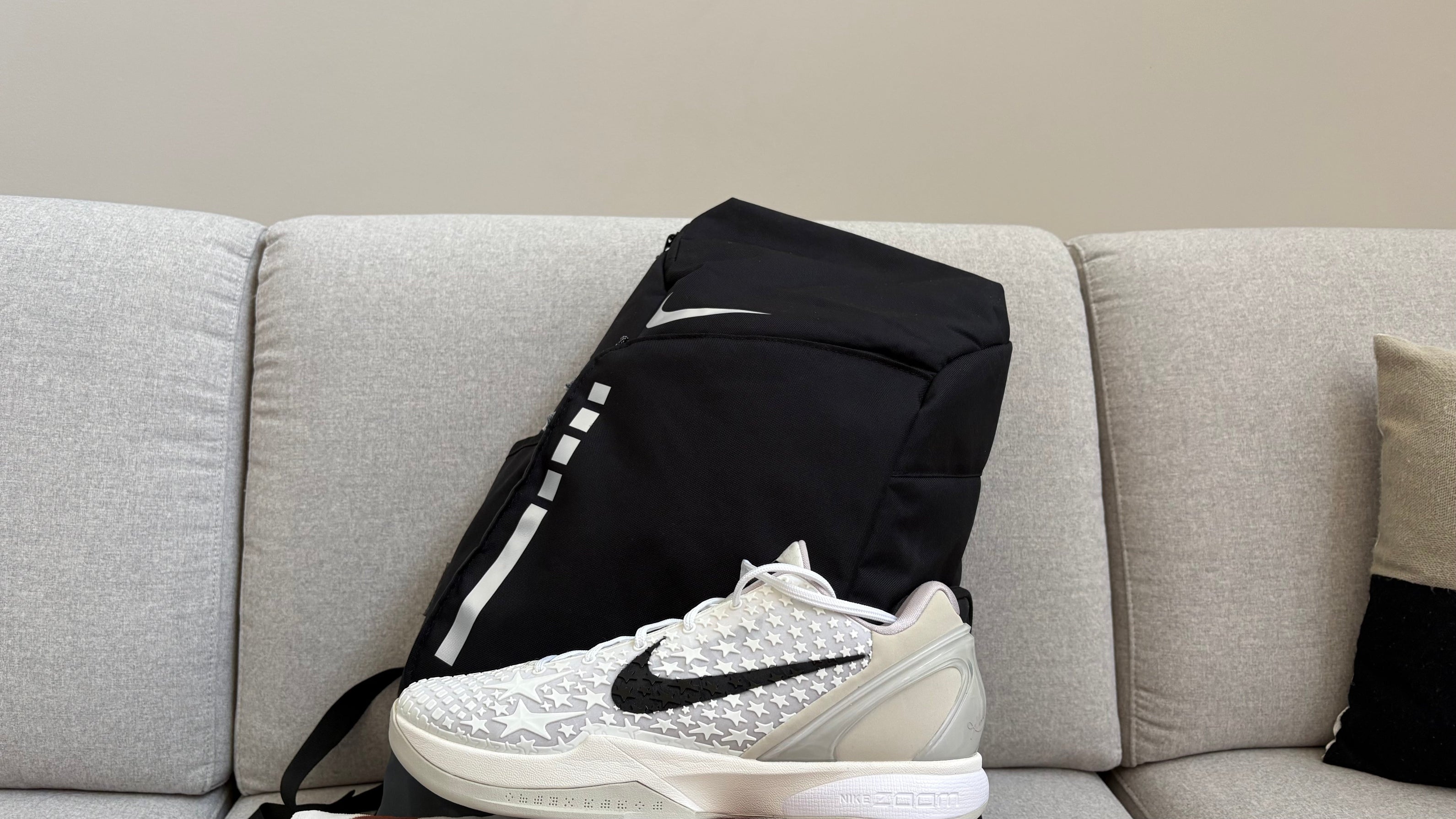 White sneaker with black Nike logo on a gray couch